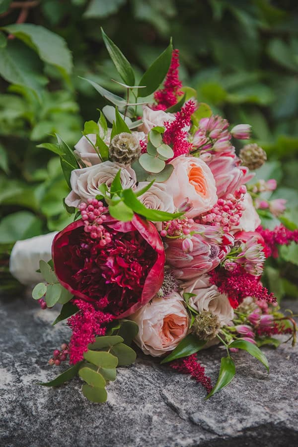 Εντυπωσιακή νυφική ανθοδέσμη με πρωτέα και παιώνιες σε μπορντό και peach