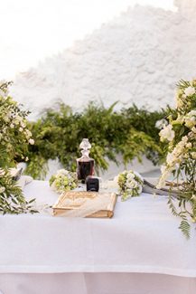 Στολισμός λαμπάδας με πλούσια πρασινάδα και λευκά λουλούδια