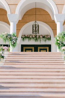 Εντυπωσιακός στολισμός εισόδου εκκλησίας με πλούσιες συνθέσεις λουλουδιών και χρυσά stands