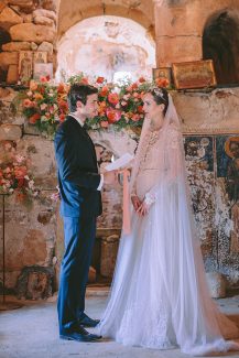 Στολισμός τελετής γάμου με πλούσιες γιρλάντες λουλουδιών σε peach αποχρώσεις