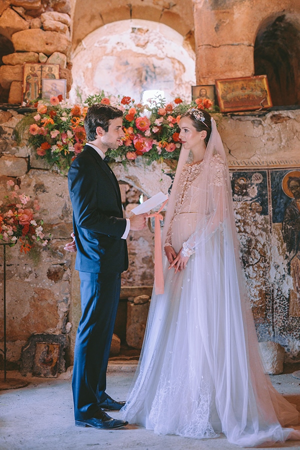 Στολισμός τελετής γάμου με πλούσιες γιρλάντες λουλουδιών σε peach αποχρώσεις