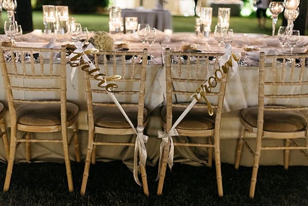Στολισμός καρέκλας για νεόνυμφους με χρυσές πινακίδες “Bride – Groom”