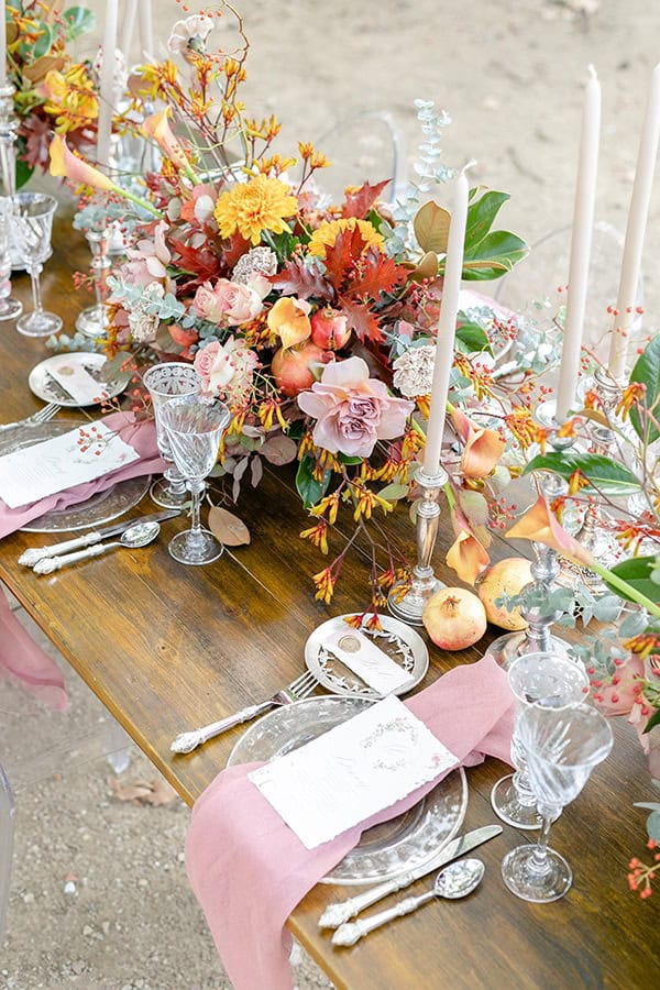 Στολισμός γαμήλιου τραπεζιού με πλούσιες ανθοσυνθέσεις από τριαντάφυλλα, ντάλιες και κρίνα σε αποχρώσεις του κίτρινου και του σάπιου μήλου