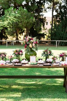 Ξύλινο candy table εμπλουτισμένο με πολύχρωμα λουλούδια