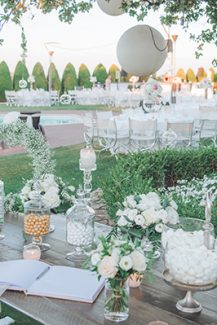 Τραπέζι ευχών διακοσμημένο με λευκά τριαντάφυλλα και γλυκήσματα Τραπέζι ευχών διακοσμημένο με λευκά τριαντάφυλλα και γλυκήσματα