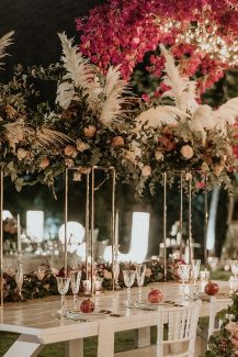 Εντυπωσιακός στολισμός τραπεζιού δεξίωσης με πλούσιες γιρλάντες από άνθη σε φούξια και ροζ τόνους Εντυπωσιακός στολισμός τραπεζιού δεξίωσης με πλούσιες γιρλάντες από άνθη σε φούξια και ροζ τόνους