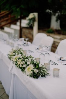 Στολισμός γαμήλιου τραπεζιού με γιρλάντα λουλουδιών Στολισμός γαμήλιου τραπεζιού με γιρλάντα λουλουδιών