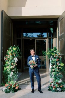 Εντυπωσιακός στολισμός εισόδου εκκλησίας με πλούσιες συνθέσεις από πρασινάδες και άλλα λουλούδια σε ζεστές αποχρώσεις Εντυπωσιακός στολισμός εισόδου εκκλησίας με πλούσιες συνθέσεις από πρασινάδες και άλλα λουλούδια σε ζεστές αποχρώσεις