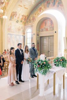 Λευκές λαμπάδες εκκλησίας διακοσμημένες με πλούσια πρασινάδα, πρωτέα και τριαντάφυλλα