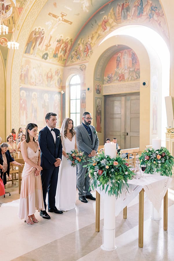 Λευκές λαμπάδες εκκλησίας διακοσμημένες με πλούσια πρασινάδα, πρωτέα και τριαντάφυλλα