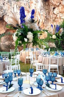 Τολμηρός στολισμός τραπεζιού δεξίωσης με πλούσιες πρασινάδες, μπλε δελφίνιουμ και pampas grass