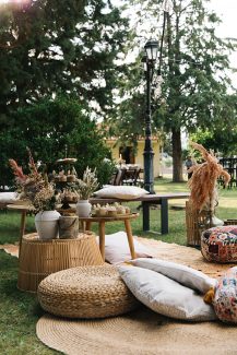 Ρουστίκ στολισμός εξωτερικού χώρου δεξίωσης με ξύλινα τραπέζια και cozy μαξιλάρια και χαλιά. Ρουστίκ στολισμός εξωτερικού χώρου δεξίωσης με ξύλινα τραπέζια και cozy μαξιλάρια και χαλιά.
