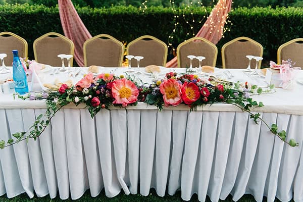 Ανοιξιάτικος στολισμός γαμήλιου τραπεζιού με λουλούδια σε ζωηρά χρώματα