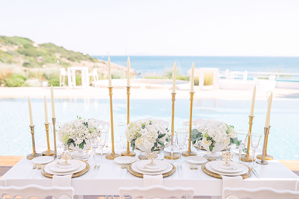 Elegant στολισμός γαμήλιου τραπεζιού με λευκά μπουκετάκια και χρυσά κεριά