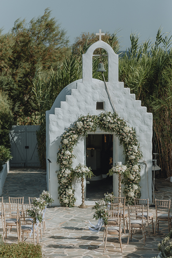 Παραμυθένιος στολισμός εισόδου εκκλησίας με πλούσιο ανθοστολισμό σε λευκές και πράσινες αποχρώσεις