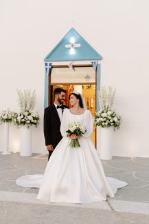 Παραμυθένια διακόσμηση εισόδου εκκλησίας με ψηλές λευκές ανθοστήλες