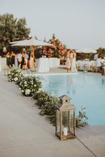 Ρομαντικός στολισμός δεξίωσης εξωτερικού χώρου με πρασινάδες και κεριά Ρομαντικός στολισμός δεξίωσης εξωτερικού χώρου με πρασινάδες και κεριά