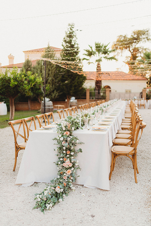 Ρουστίκ στολισμός τραπεζιού δεξίωσης με γιρλάντα λουλουδιών σε παστέλ αποχρώσεις