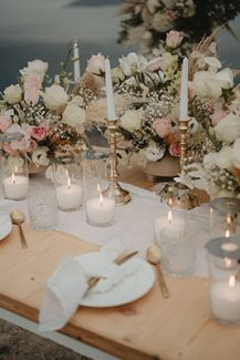 Ρομαντικός στολισμός γαμήλιου τραπεζιού με λευκά κεριά και λουλούδια