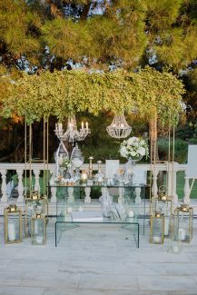 Elegant chic στολισμός candy table με γυάλινες βάσεις και πρασινάδα