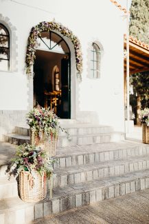 Εντυπωσιακός στολισμός εισόδου εκκλησίας από ψάθινα καλάθια και γιρλάντα λουλουδιών