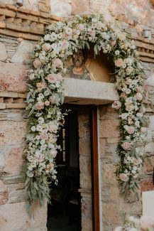 Πανέμορφος στολισμός εισόδου εκκλησίας με πλούσια γιρλάντα σε παστέλ αποχρώσεις