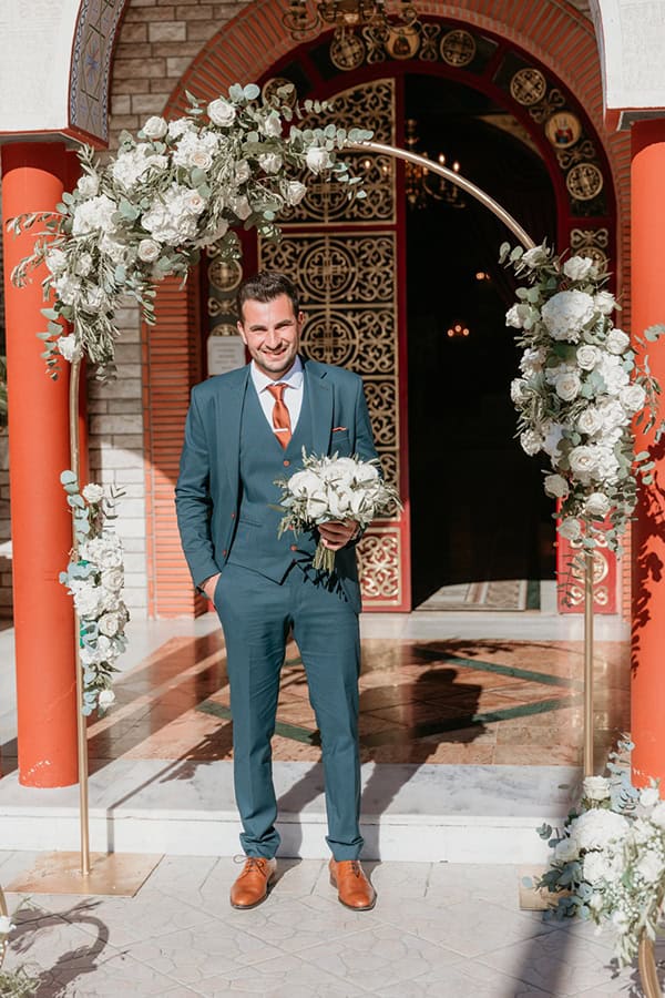 Στολισμός εισόδου εκκλησίας με χρυσή αψίδα και λευκά λουλούδια