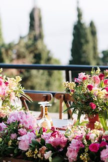 Πλούσιος στολισμός γαμήλιου τραπεζιού με γιρλάντα από φούξια λουλούδια