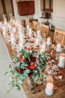 Ξεχωριστός στολισμός γαμήλιου τραπεζιού με αμέτρητα κεριά και ροδοπέταλα