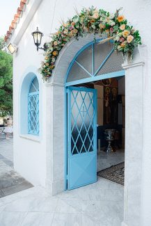 Μποέμ στολισμός εισόδου εκκλησίας με γιρλάντα λουλουδιών σε υπέροχες αποχρώσεις του peach