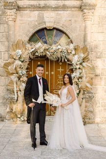 Ιδιαίτερος στολισμός εισόδου εκκλησίας με αψίδα λουλουδιών Ιδιαίτερος στολισμός εισόδου εκκλησίας με αψίδα λουλουδιών