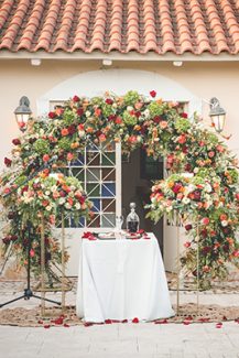 Μοντέρνος στολισμός τελετής γάμου με αψίδα λουλουδιών και χρυσές ανθοστήλες