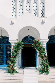 Πλούσιος στολισμός εισόδου εκκλησίας με τροπικά άνθη και πρασινάδες