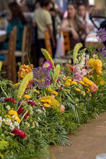 Ρουστίκ στολισμός γαμήλιου τραπεζιού με πλούσια γιρλάντα από λουλούδια του αγρού