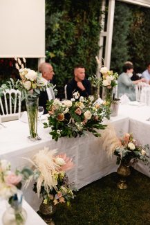 Στολισμός γαμήλιου τραπεζιού με πλούσιες ανθοσυνθέσεις