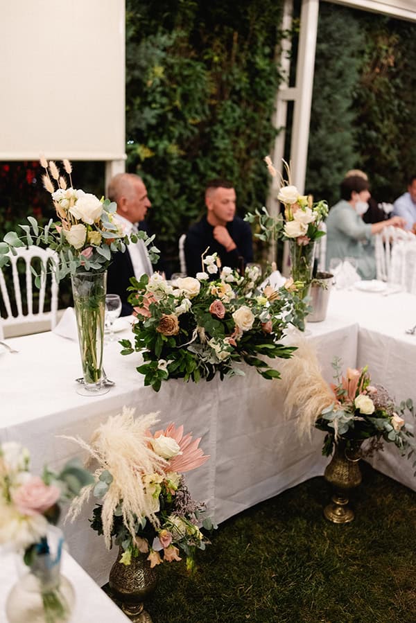 Στολισμός γαμήλιου τραπεζιού με πλούσιες ανθοσυνθέσεις Στολισμός γαμήλιου τραπεζιού με πλούσιες ανθοσυνθέσεις