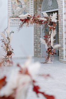 Ξύλινη λουλουδένια αψίδα από αποξηραμένα λουλούδια και λευκά pampas grass