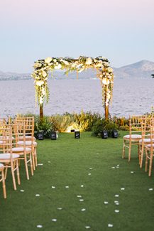 Ρομαντική τετράγωνη αψίδα λουλουδιών με λευκά άνθη και πλούσια πρασινάδα