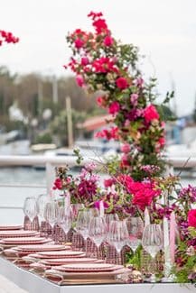 Μοντέρνος στολισμός τραπεζιών δεξίωσης με runner από φούξια τριαντάφυλλα