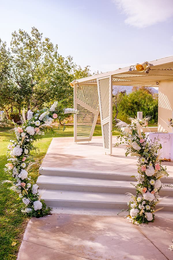 Ρομαντική αψίδα λουλουδιών με peach ανθούρια και ιβουάρ ορτανσίες