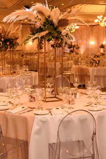 Μποέμ στολισμός τραπεζιών δεξίωσης με pampas grass πάνω σε χρυσά stand