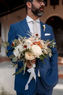 Υπέροχη νυφική ανθοδέσμη με μπουργουντί κρασπέδια και ιβουάρ παιώνιες