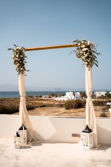 Rustic ξύλινη αψίδα με ανθοσυνθέσεις από τριαντάφυλλα και κλαδιά ελιάς Rustic ξύλινη αψίδα με ανθοσυνθέσεις από τριαντάφυλλα και κλαδιά ελιάς