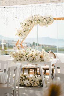 Εντυπωσιακή διακόσμηση γαμήλιου τραπεζιού με πληθώρα λουλουδιών