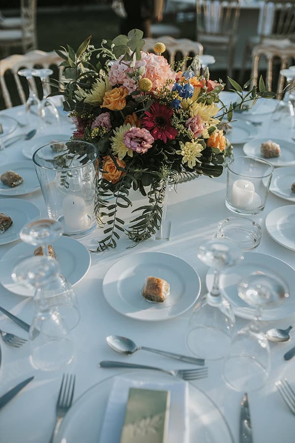 Όμορφος στολισμός τραπεζιών δεξίωσης με κόκκινα χρυσάνθεμα και κρασπέδια